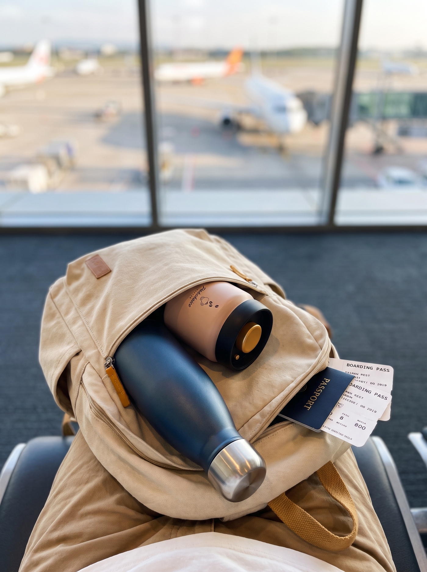 Travel bottle and coffee canister in a backpack at the airport gate